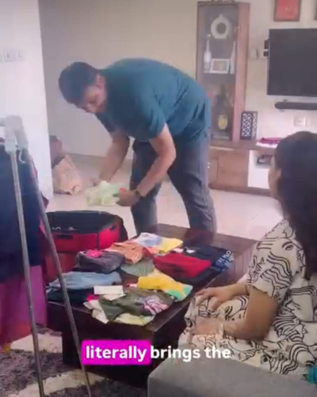 Two parents unpacking a Skipzy case of children's clothing in their living room