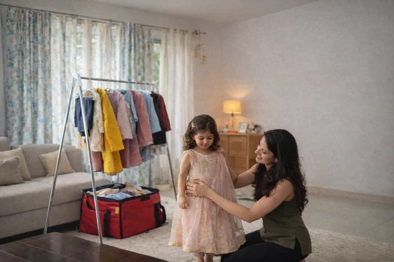 Happy mom and child trying clothes at home
